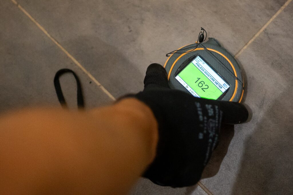Disaster Care technician using acoustic listening equipment for water leak detection 